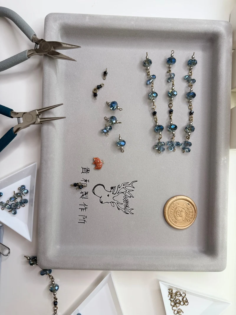 制作中の青いクリスタルガラスのパーツと工具